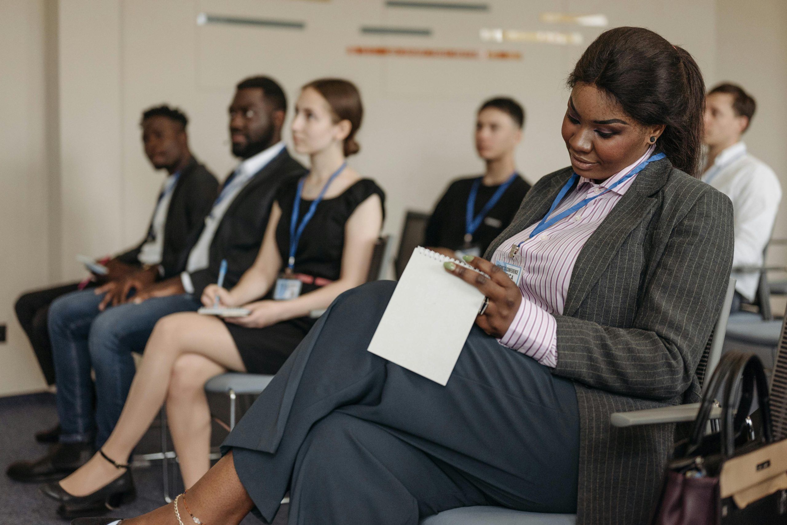 Business professionals engaged in a seminar, taking notes and listening attentively.